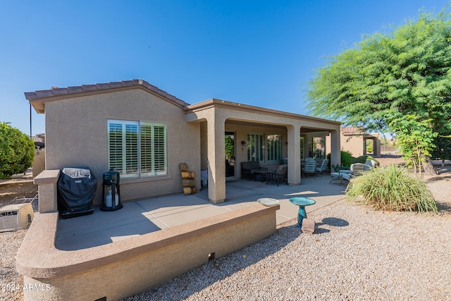 rear view of house featuring a patio and an outdoor living space