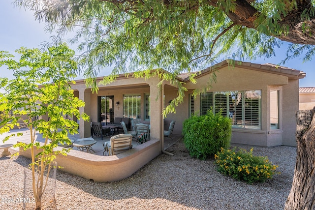 back of property with outdoor lounge area and a patio