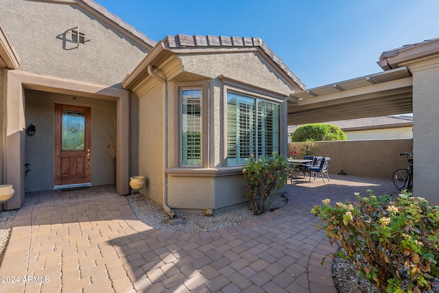 view of exterior entry featuring a patio area