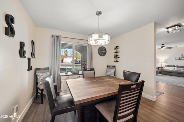 dining room featuring dark wood-type flooring and ceiling fan with notable chandelier