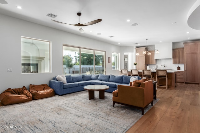 living room featuring ceiling fan and light hardwood / wood-style flooring