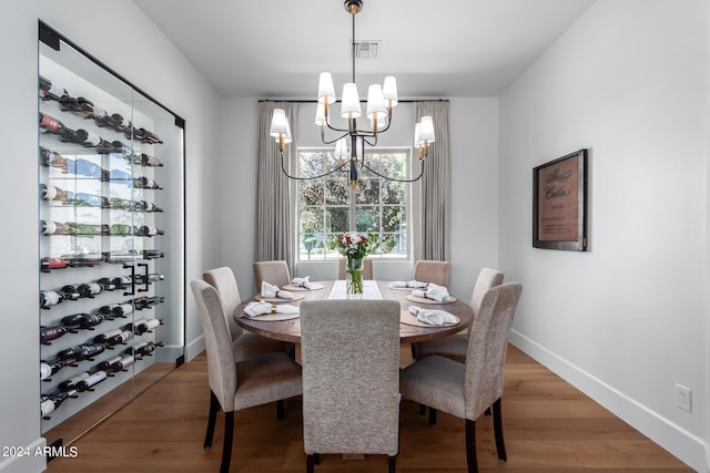 dining space with hardwood / wood-style flooring and a notable chandelier