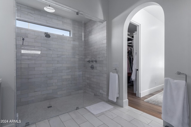 bathroom featuring a tile shower and hardwood / wood-style flooring