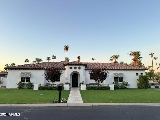 mediterranean / spanish home with a lawn