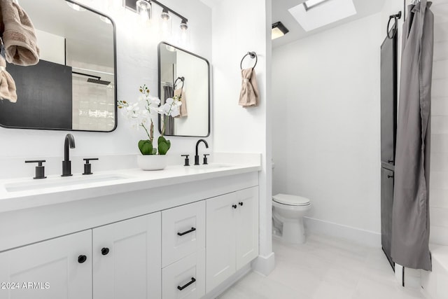 bathroom featuring vanity, a skylight, and toilet