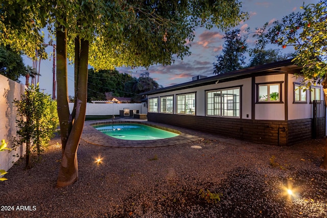 pool at dusk featuring a patio