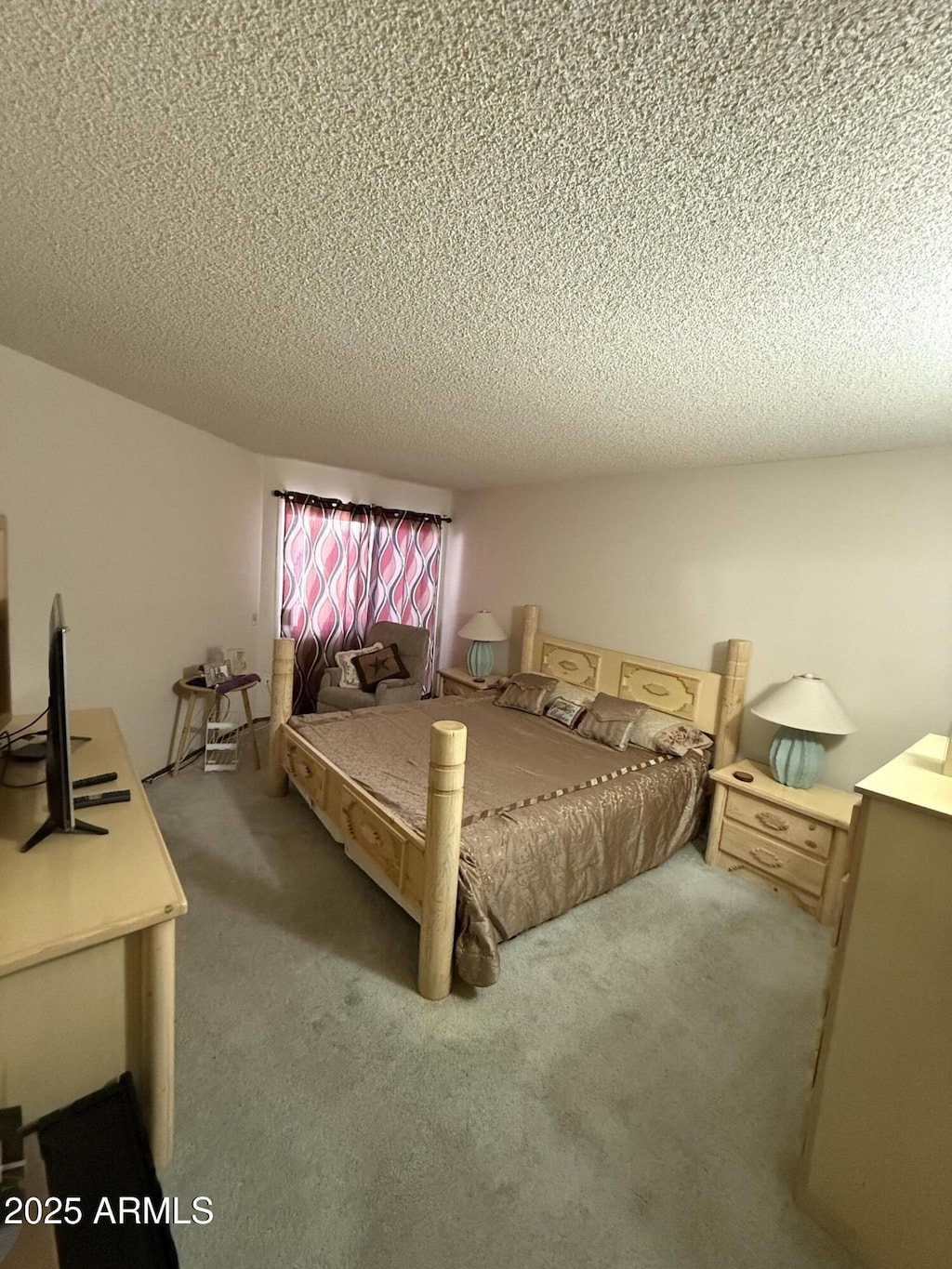 bedroom with carpet and a textured ceiling