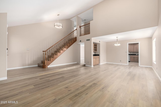 unfurnished living room with a high ceiling and hardwood / wood-style floors