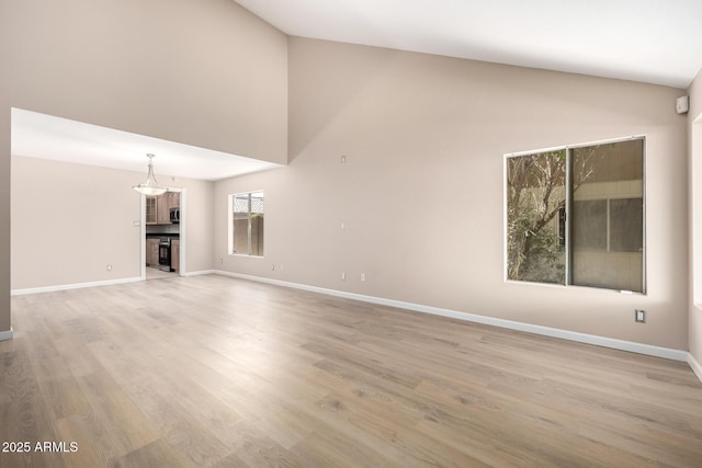 unfurnished living room with high vaulted ceiling and light wood-type flooring