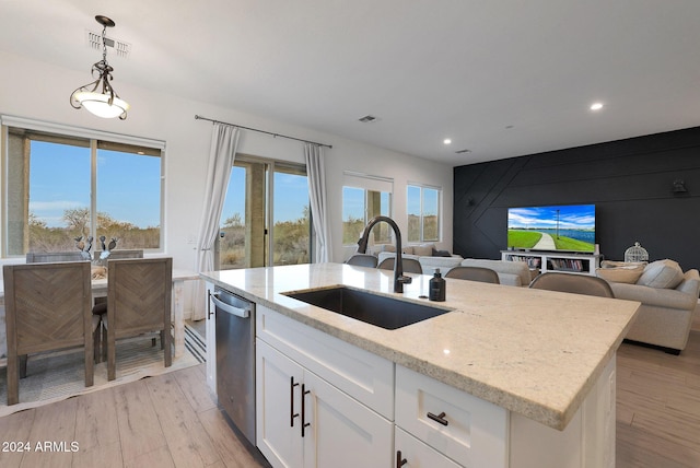 kitchen featuring sink, white cabinetry, dishwasher, light stone countertops, and pendant lighting