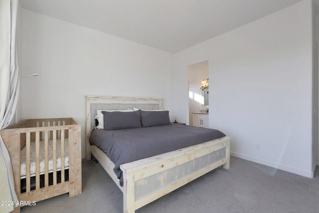 bedroom with dark carpet and connected bathroom