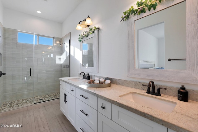 bathroom with a shower with door and vanity