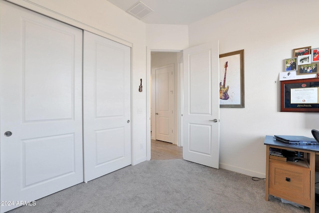 unfurnished bedroom with light colored carpet and a closet