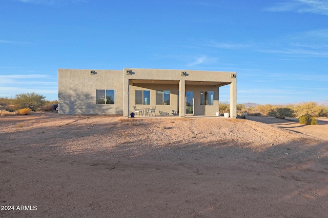 pueblo revival-style home with a patio area