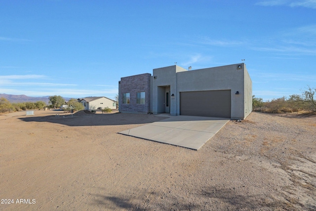 pueblo-style home with a mountain view and a garage