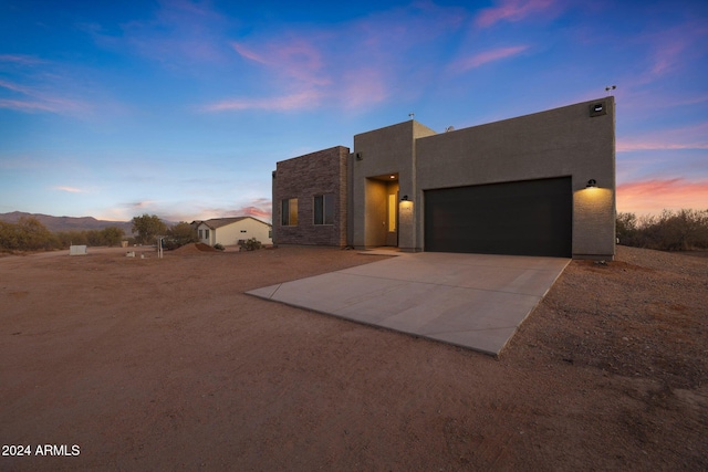 pueblo-style home with a garage and a mountain view