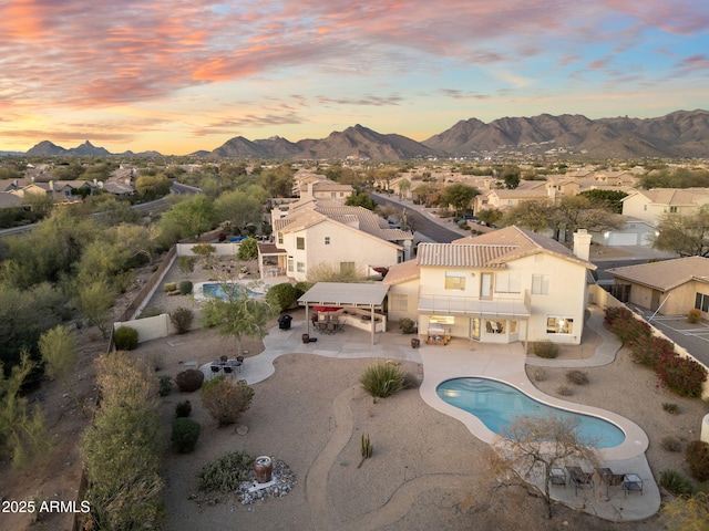aerial view at dusk featuring a residential view and a mountain view