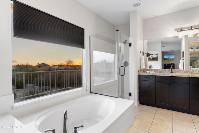 bathroom featuring tile patterned flooring, vanity, a shower stall, a garden tub, and visible vents