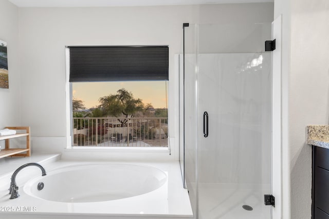 bathroom with a bath, a stall shower, and vanity