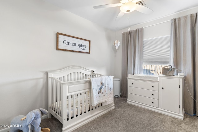 carpeted bedroom featuring a ceiling fan and a nursery area