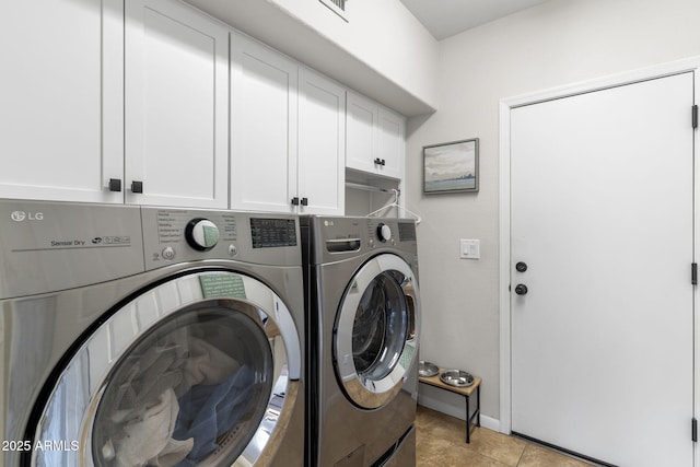 clothes washing area with light tile patterned flooring, cabinet space, and washer and clothes dryer
