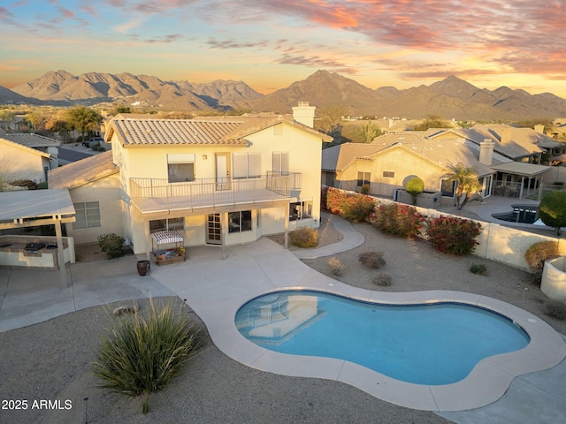 view of swimming pool featuring a fenced backyard, a fenced in pool, a mountain view, and a patio