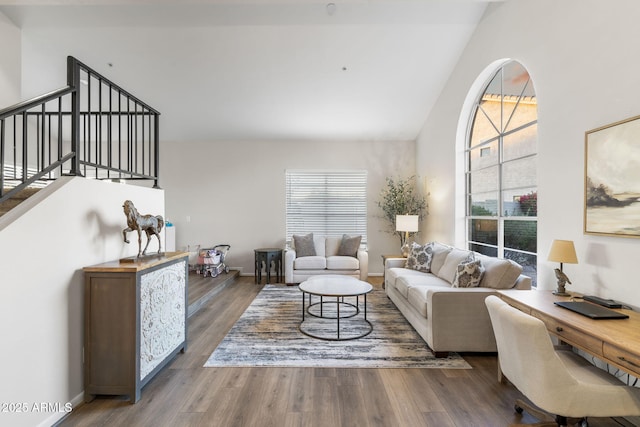 living area featuring baseboards, a healthy amount of sunlight, and wood finished floors