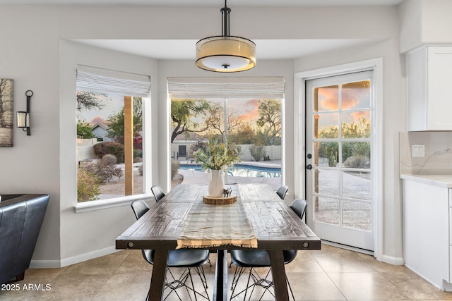 dining space featuring light tile patterned flooring and baseboards