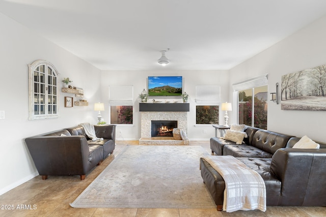 living area featuring baseboards and a fireplace