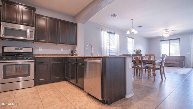 18269 W Vogel Ave, Waddell, AZ 85355 - kitchen with stainless steel appliances, plenty of natural light, dark brown cabinets, and a peninsula