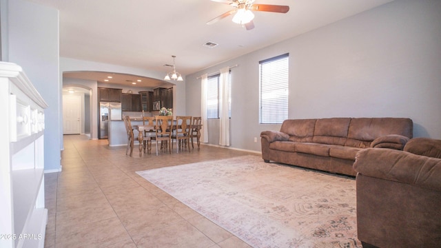 18269 W Vogel Ave, Waddell, AZ 85355 - living room with arched walkways, a ceiling fan, light tile patterned floors, a chandelier, and baseboards