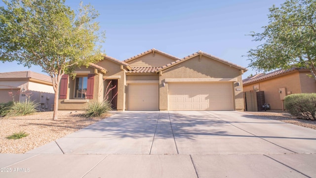 18269 W Vogel Ave, Waddell, AZ 85355 - view of front of house featuring an attached garage, concrete driveway, stucco siding, and a tile roof