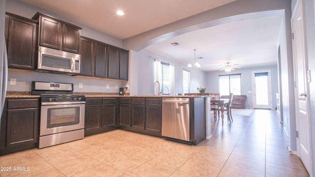 18269 W Vogel Ave, Waddell, AZ 85355 - kitchen featuring stainless steel appliances, a peninsula, dark brown cabinets, arched walkways, and open floor plan