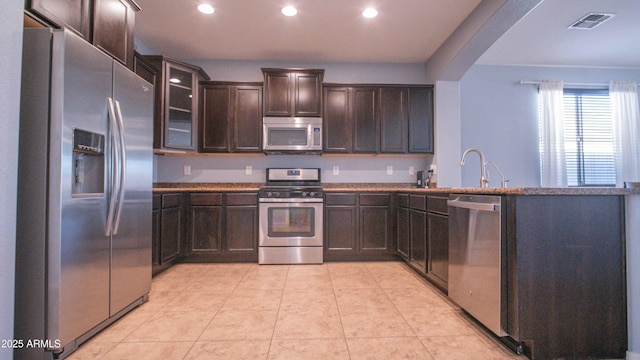 18269 W Vogel Ave, Waddell, AZ 85355 - kitchen with stainless steel appliances, a peninsula, dark brown cabinets, arched walkways, and recessed lighting