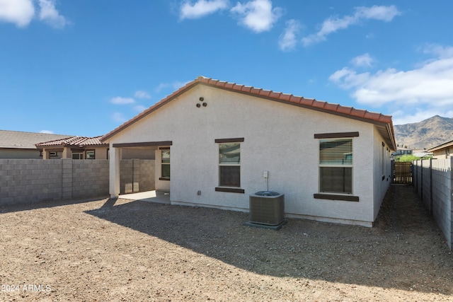 rear view of property featuring a mountain view and central AC unit