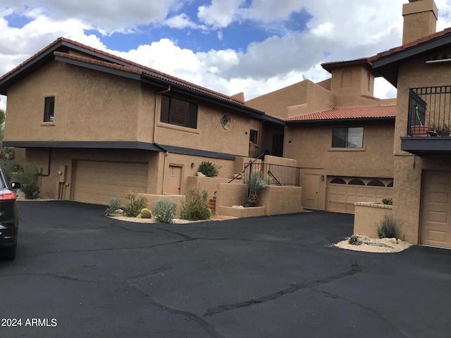 view of front of property with a garage and a balcony