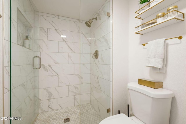 bathroom featuring toilet and a shower with shower door