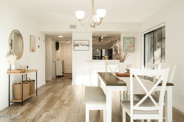 dining room with a chandelier and light wood-type flooring