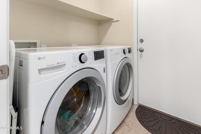 washroom featuring light tile patterned floors and washer and dryer