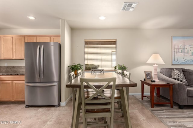 kitchen featuring light brown cabinetry and stainless steel fridge