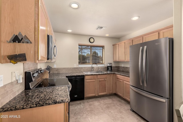 kitchen with sink, dark stone countertops, kitchen peninsula, and stainless steel appliances