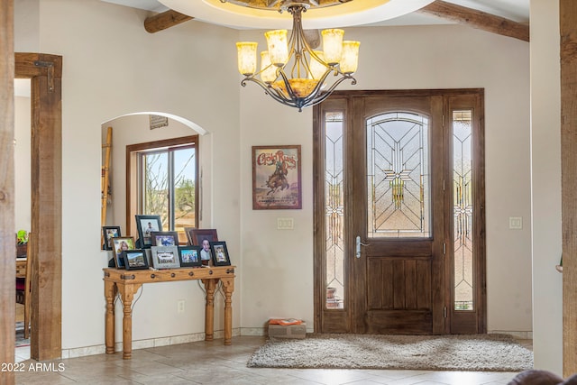 foyer with beam ceiling and an inviting chandelier