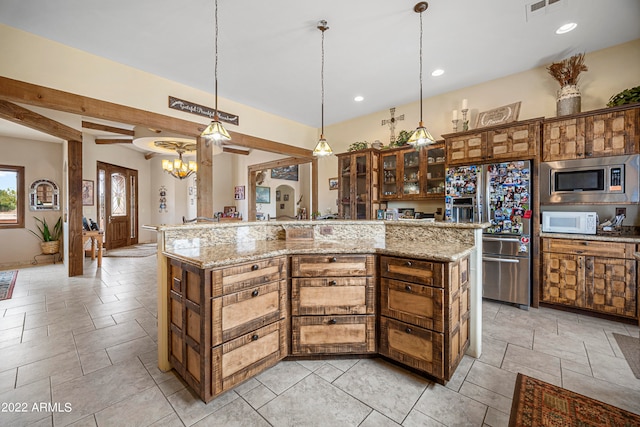 kitchen featuring light stone countertops, appliances with stainless steel finishes, a large island with sink, decorative light fixtures, and a notable chandelier