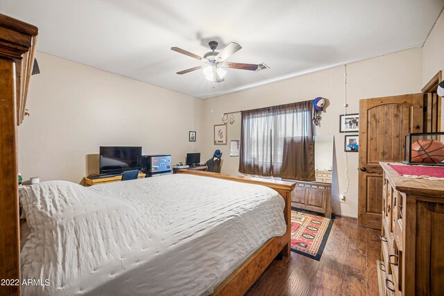 bedroom with dark hardwood / wood-style flooring and ceiling fan