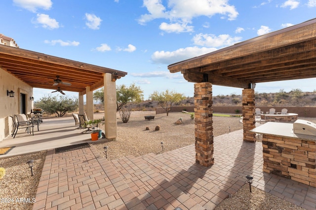 view of patio featuring an outdoor kitchen, area for grilling, and ceiling fan