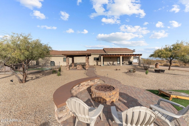 rear view of house with a patio area and a fire pit