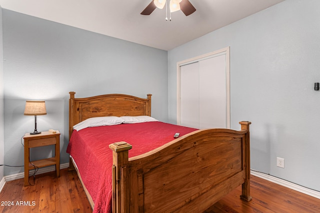 bedroom featuring ceiling fan, dark hardwood / wood-style flooring, and a closet