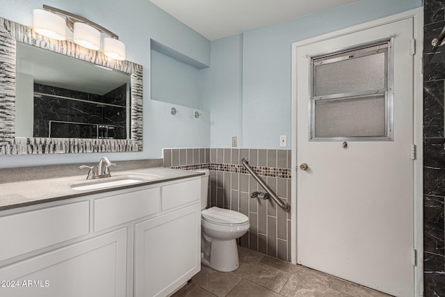 bathroom featuring walk in shower, vanity, toilet, and tile walls