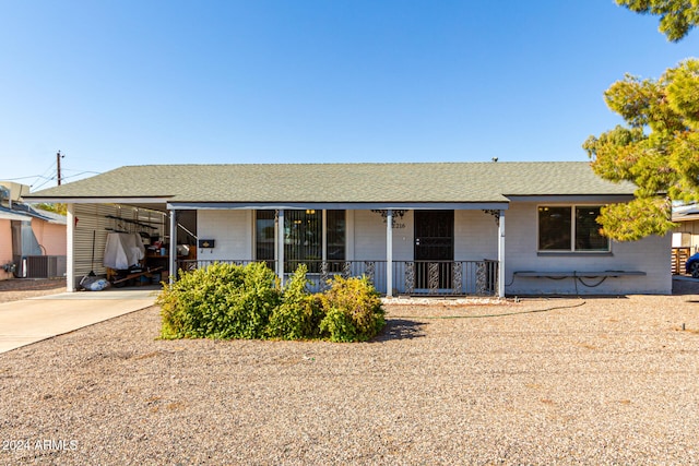 single story home featuring a carport, cooling unit, and covered porch