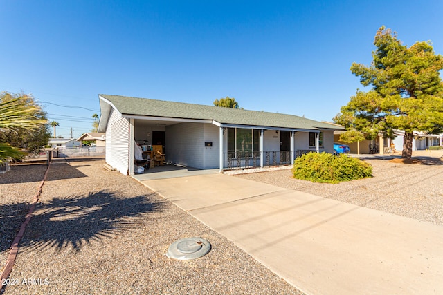 ranch-style house featuring a carport and covered porch